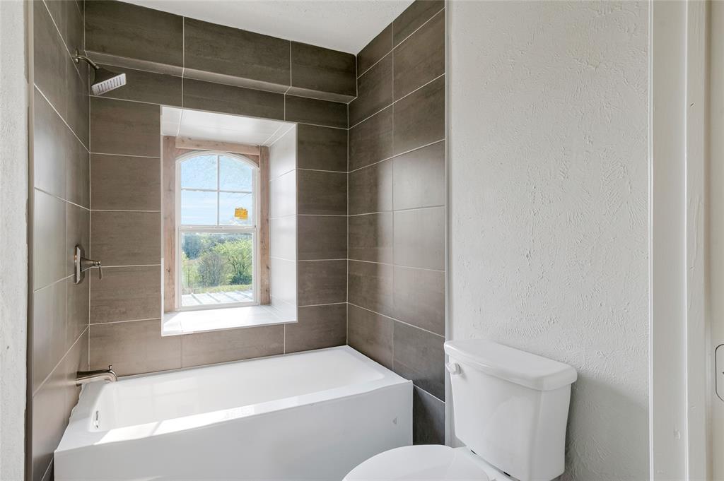 41 Kelsey Road Denison, TX 75021 - Photo 21 of 31 Updated primary bathroom with new tub, shower surround and toilet.