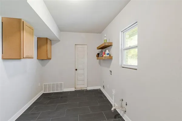 a view of an entryway with wooden floor and cabinet
