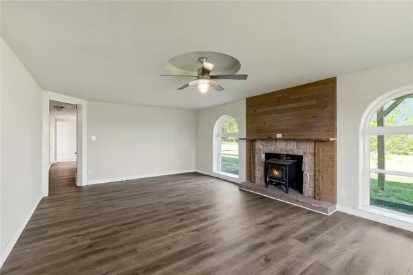 a view of an empty room with a fireplace and a window