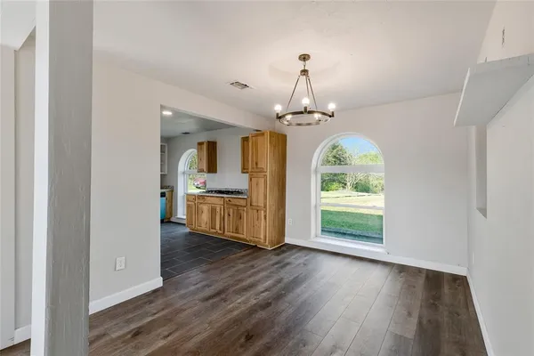 a view of a room with wooden floor couches and a kitchen view