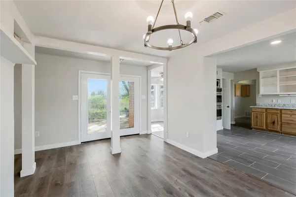a view of a big room with wooden floor and windows