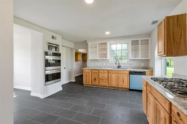a kitchen with stainless steel appliances a stove a sink and a refrigerator