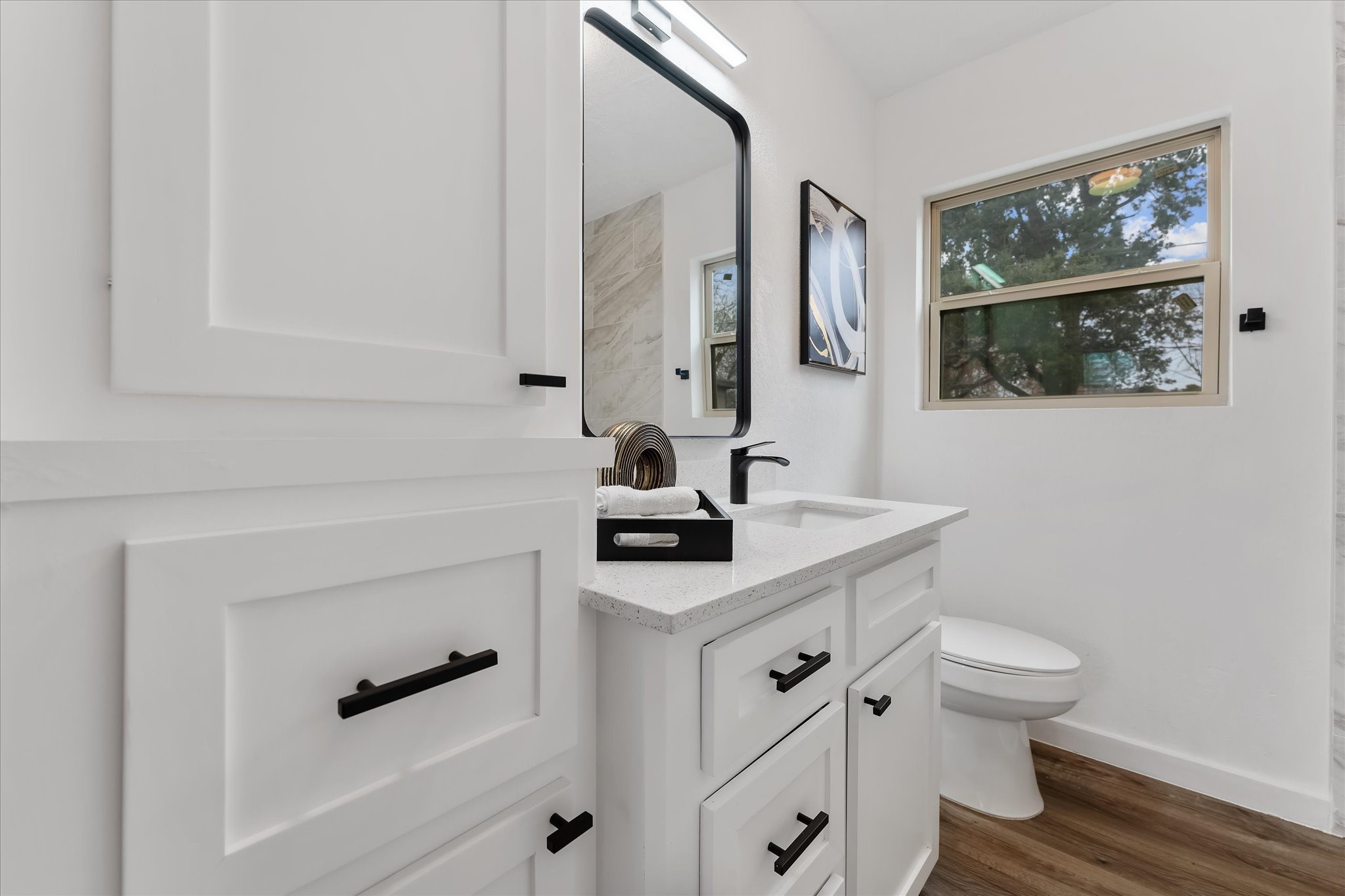 4915 Andrea Street Houston, TX 77021 - Photo 11 of 19 Secondary bathroom with a framed mirror, vinyl plank floors, and granite countertops.