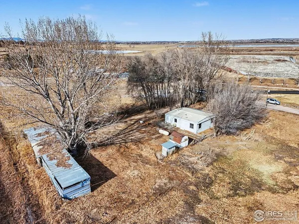 a backyard of a house with large trees and outdoor seating