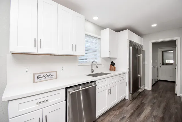 a kitchen with a refrigerator a sink and cabinets