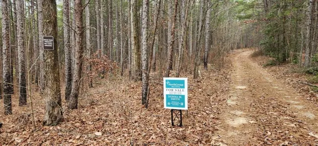 a sign board with a bench in the background