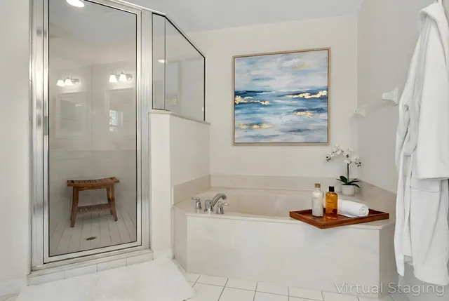 a bathroom with a tub a mirror and shower