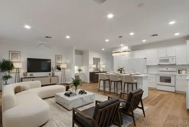 a living room with furniture kitchen view and a flat screen tv