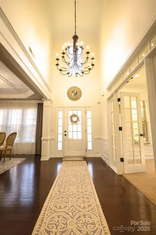 a dining room with furniture a chandelier and wooden floor