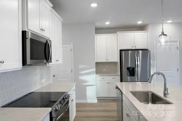 a kitchen with stainless steel appliances a refrigerator sink and microwave