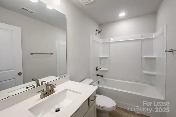 a bathroom with a sink toilet vanity and shower