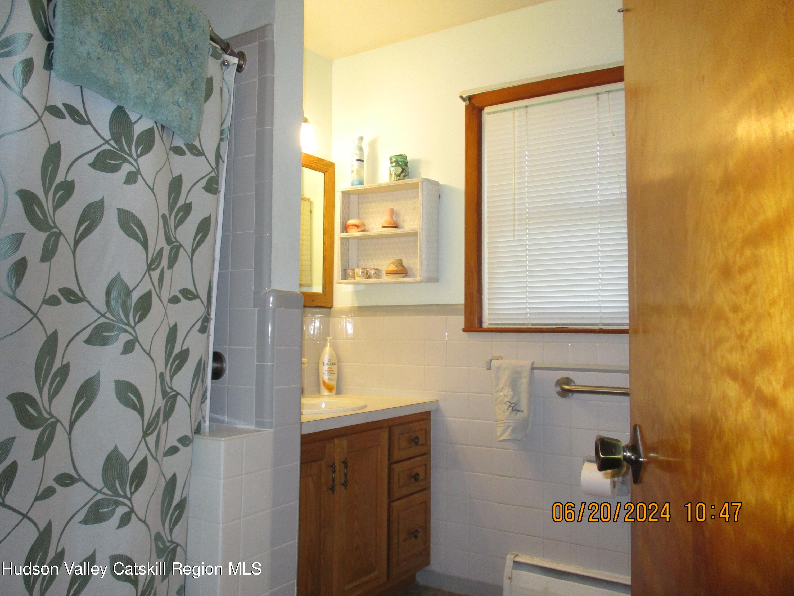 611 Plainfield Street Kingston, NY 12401 - Photo 15 of 27 a bathroom with a shower curtain and a window