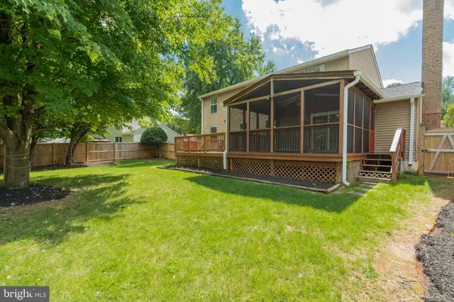 a view of a house with backyard and a tree
