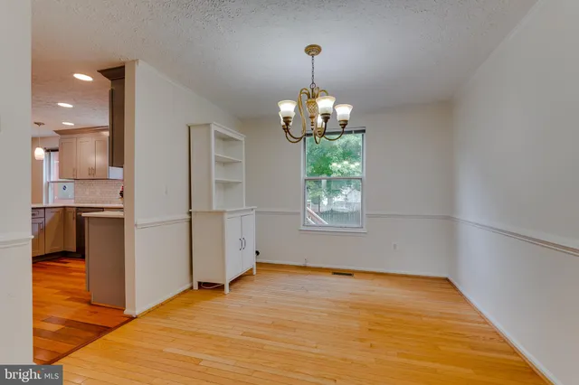 a view of a room with wooden floor kitchen and a window
