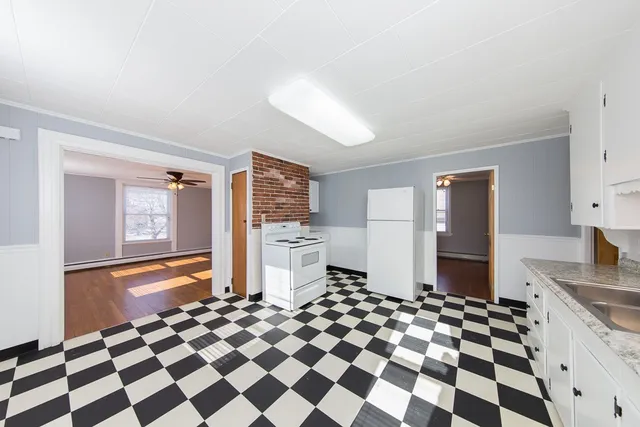 a kitchen with a checkered floor and white cabinets