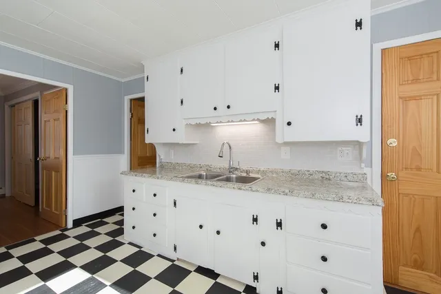 a kitchen with granite countertop white cabinets and stainless steel appliances