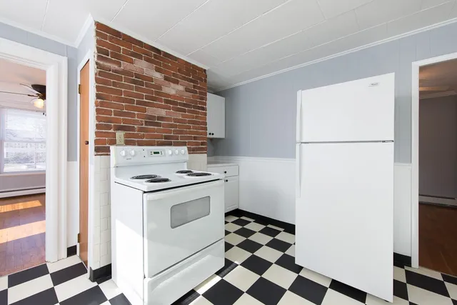 a kitchen with a stove a refrigerator and a stove top oven