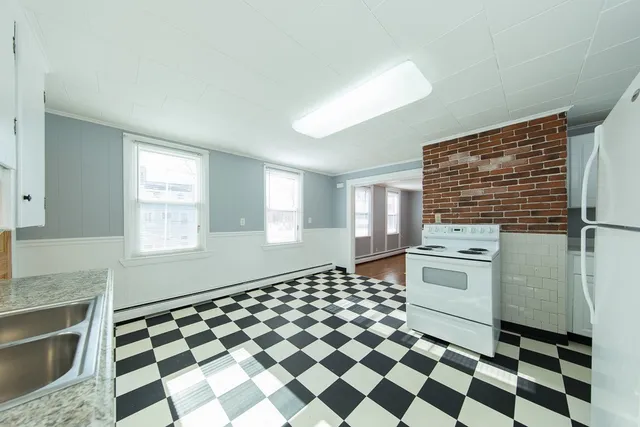 a kitchen with a checkered floor and white cabinets