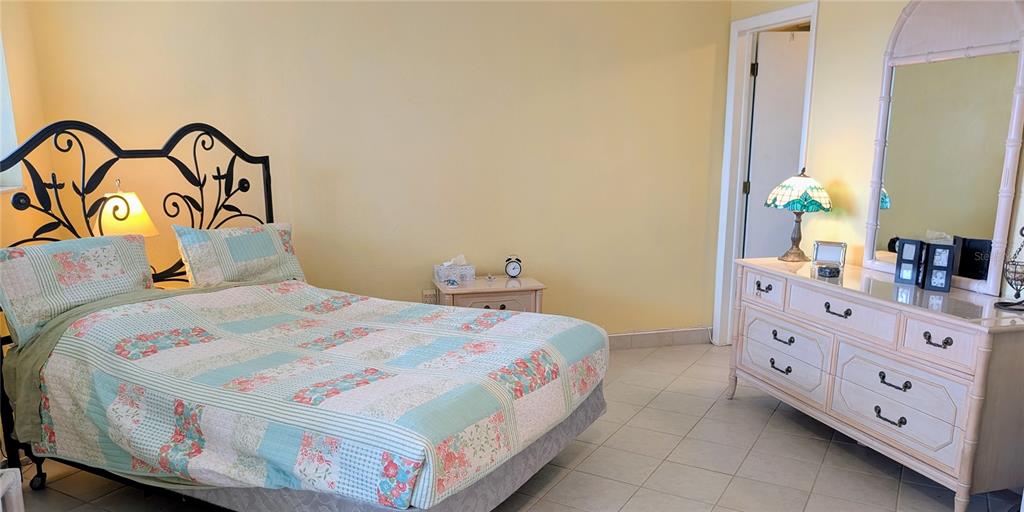 8055 112th Street North, Unit 403 Seminole, FL 33772 - Photo 18 of 37 a bedroom with a bed and a dresser in it