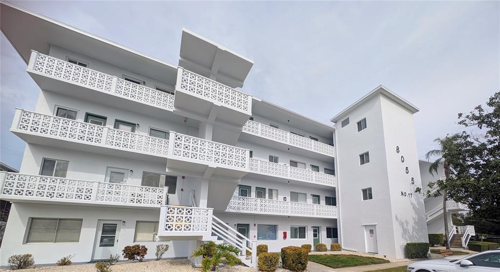 8055 112th Street North, Unit 403 Seminole, FL 33772 - Photo 37 of 37 a front view of a building with a garden and plants