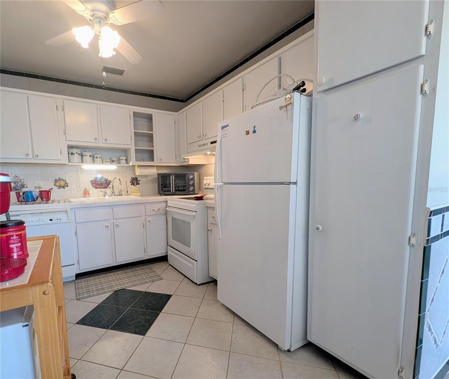 8055 112th Street North, Unit 403 Seminole, FL 33772 - Photo 7 of 37 a kitchen with a refrigerator a sink and cabinets