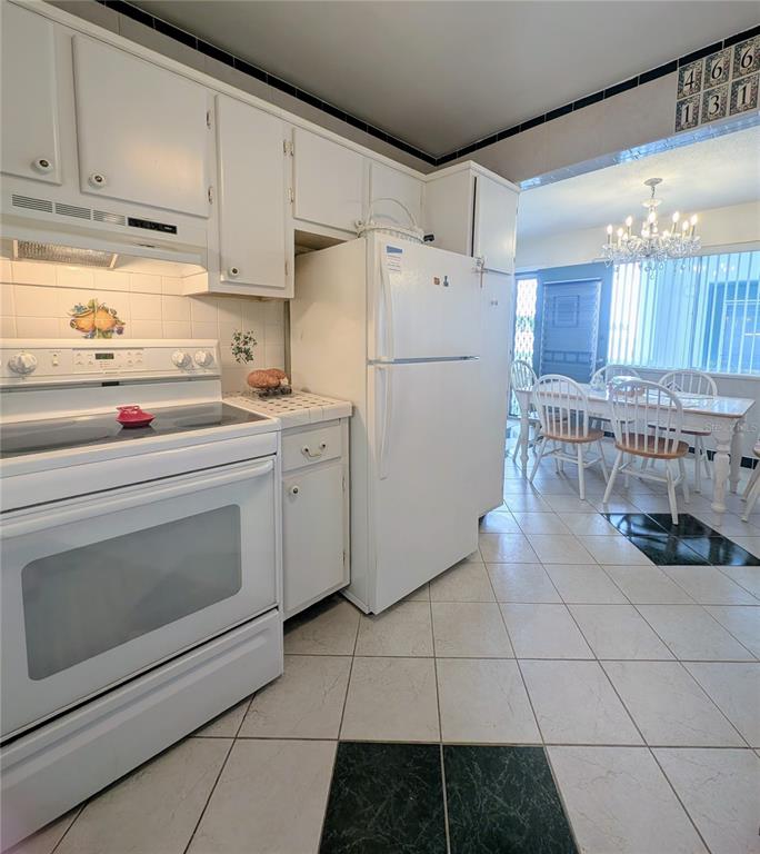 8055 112th Street North, Unit 403 Seminole, FL 33772 - Photo 9 of 37 a kitchen with a stove a sink and a refrigerator