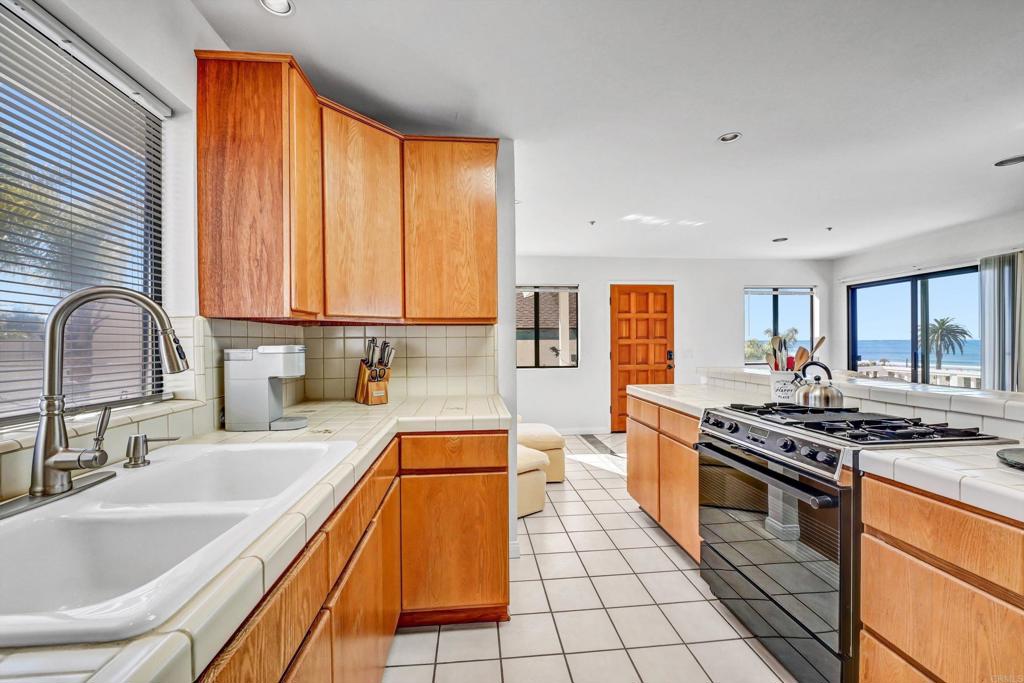 223 3rd Street Encinitas, CA 92024 - Photo 25 of 68 a kitchen with stainless steel appliances granite countertop a stove a sink and a microwave