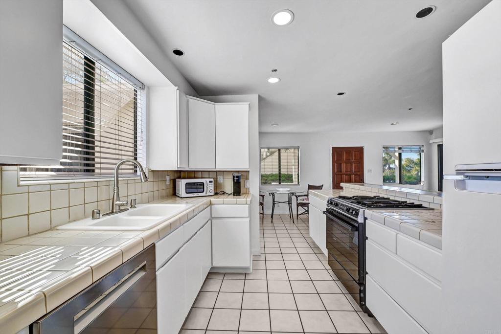 223 3rd Street Encinitas, CA 92024 - Photo 53 of 68 a kitchen with a sink stove top oven and cabinets
