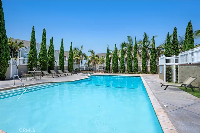 a view of house with swimming pool and outdoor seating