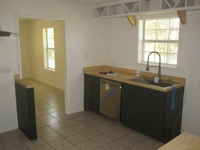 a kitchen with a sink a window and cabinets