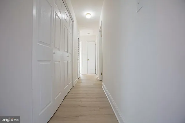 a view of a hallway with wooden floor