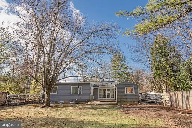 a front view of house with yard and trees around