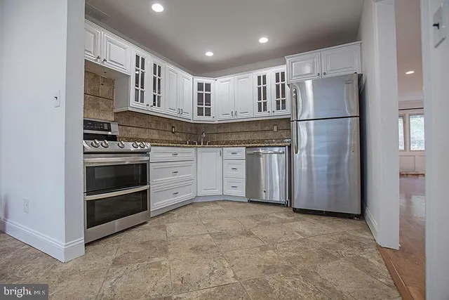 a kitchen with stainless steel appliances granite countertop a refrigerator and a stove