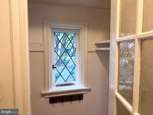 a view of an empty room with wooden floor fireplace and a window