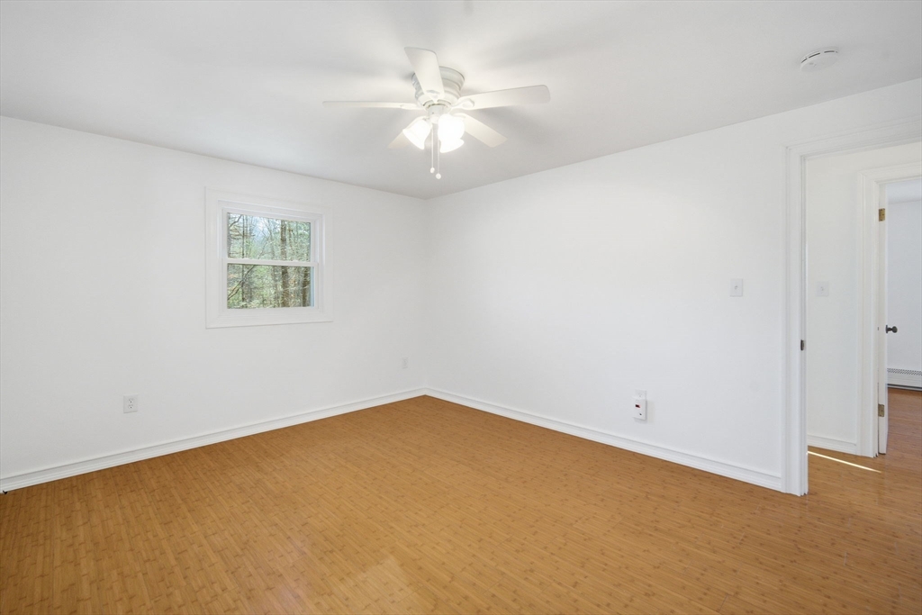 7 Fuller Road Sutton, MA 01590 - Photo 19 of 29 an empty room with a chandelier fan and windows
