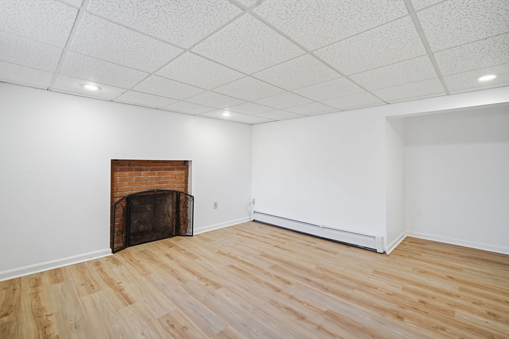 7 Fuller Road Sutton, MA 01590 - Photo 22 of 29 a view of empty room with wooden floor and fireplace