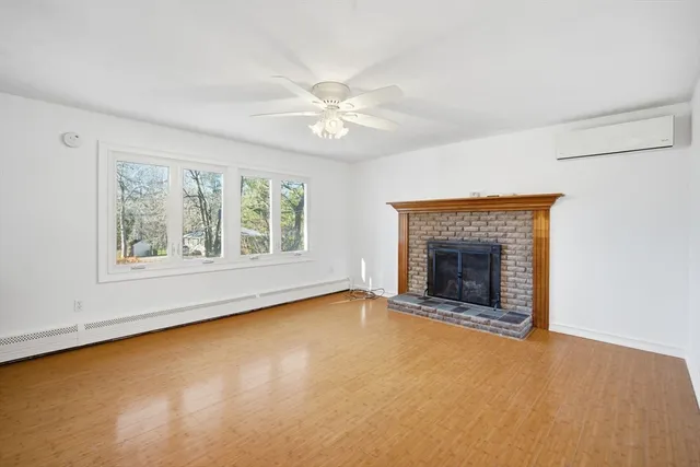 an empty room with windows and fireplace
