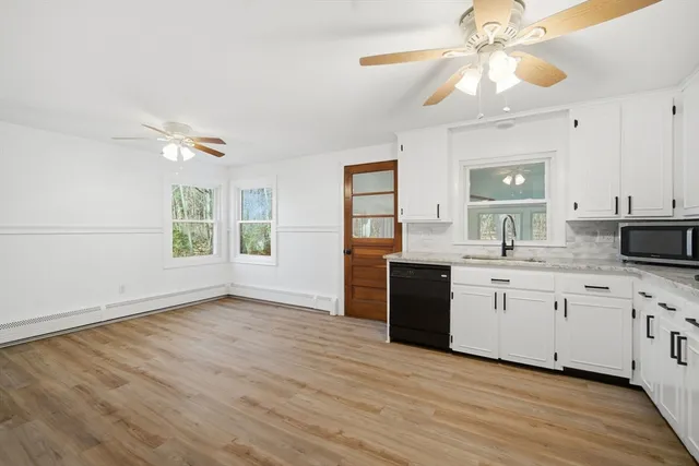 a kitchen with granite countertop a stove a sink and a microwave