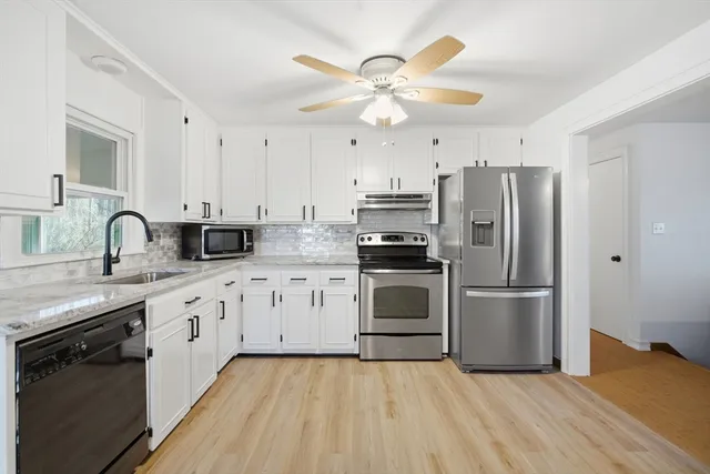 a kitchen with cabinets stainless steel appliances and a window