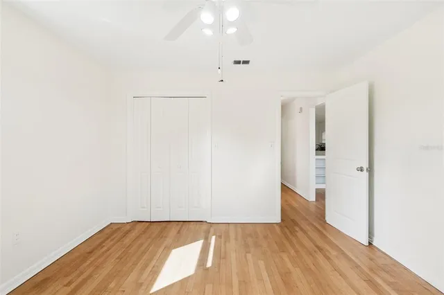 an empty room with a window and wooden floor
