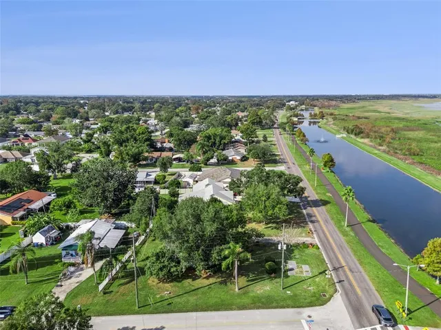 an aerial view of residential houses with outdoor space and trees