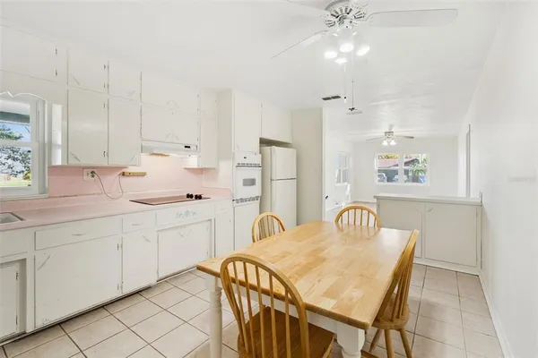 a kitchen with white cabinets and appliances