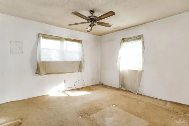 an empty room with a ceiling fan and a window