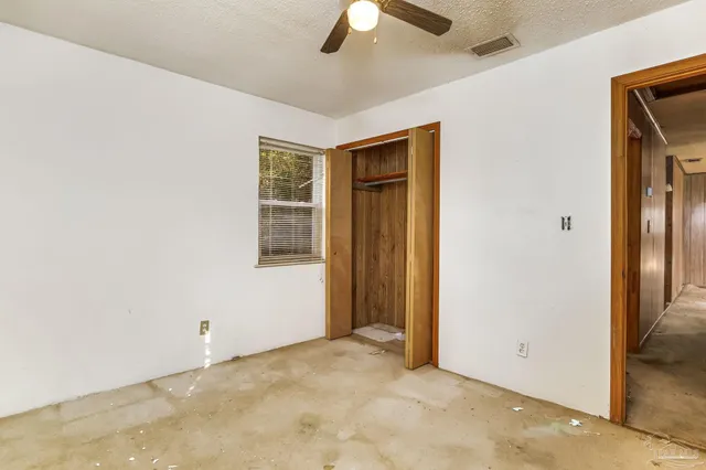 an empty room with windows and closet