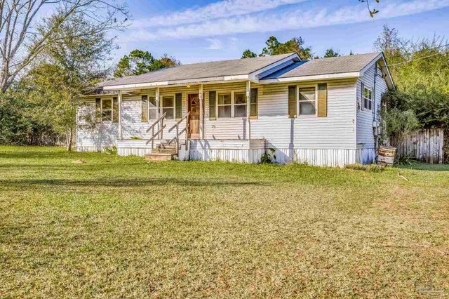 a view of a house with a big yard and potted plants