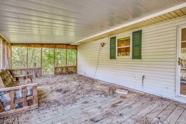 a view of a bedroom with a bed and wooden floor