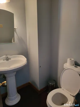 a bathroom with a sink toilet and a mirror