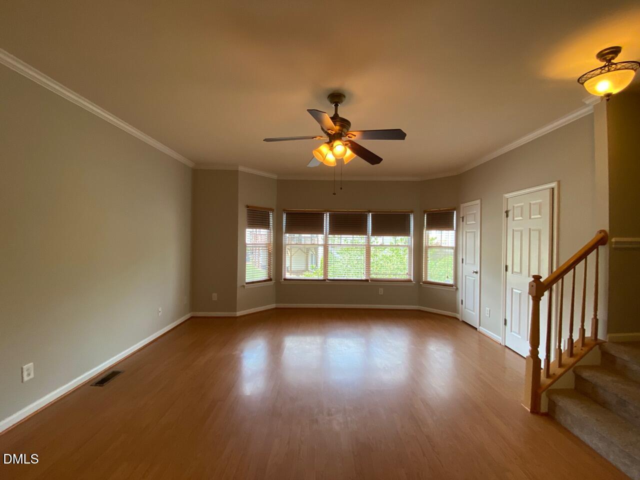 134 Darley Dale Loop Apex, NC 27502 - Photo 13 of 23 a view of empty room with wooden floor and fan