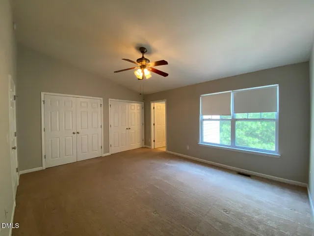 an empty room with a window and a ceiling fan