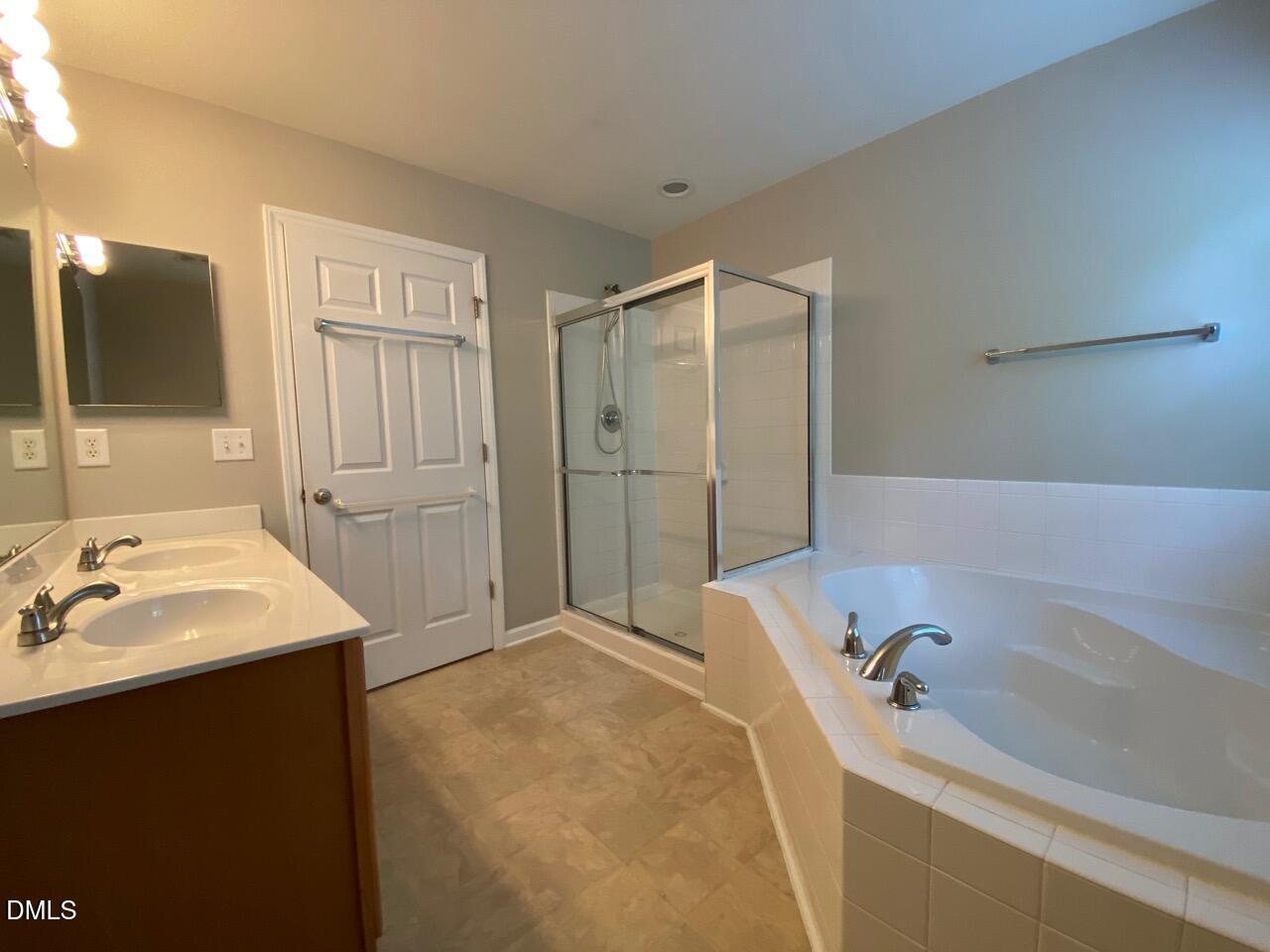 134 Darley Dale Loop Apex, NC 27502 - Photo 18 of 23 a bathroom with a tub sink and mirror